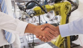 Close-up shot of a handshake in manufacturing environment