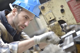 Industrial worker working on machine in factory