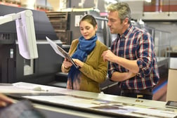 Man in printing house showing client printed documents
